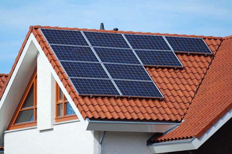Painéis solares num telhado de uma casa.