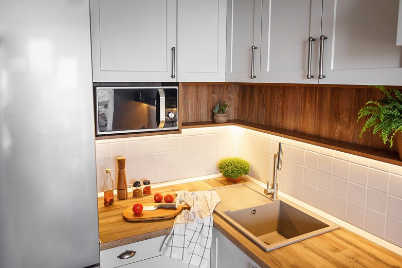 Cozinha bem equipada com um lava-louça, um micro-ondas e uma bancada para cozinhar.