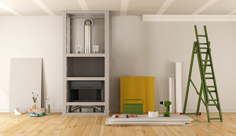 Uma sala vazia com uma escadote e ferramentas de remodelação.