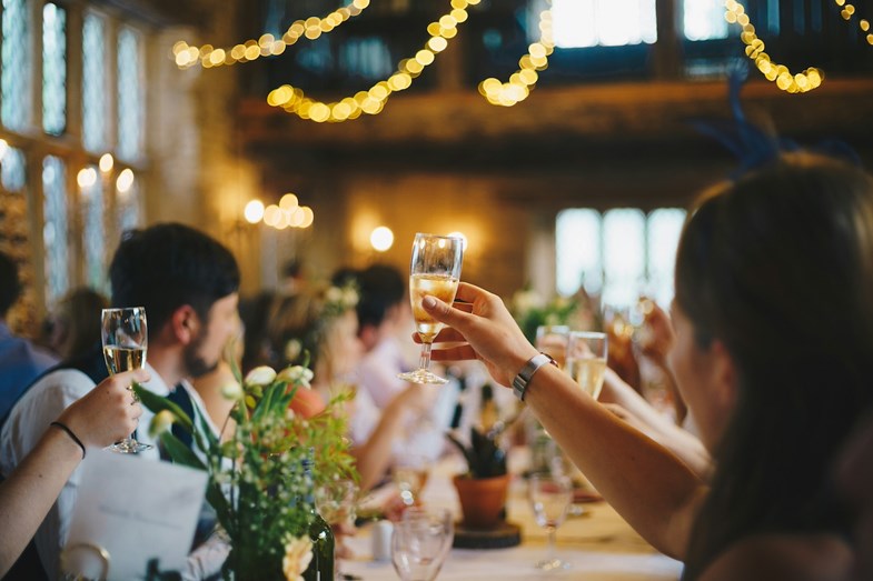 Convidados a fazer um brinde aos noivos num casamento.