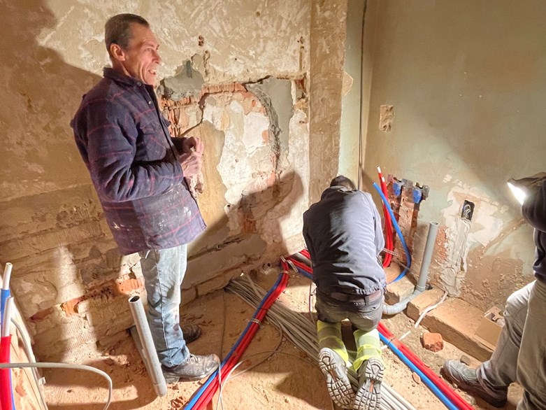 Um grupo de homens a trabalhar durante a remodelação de uma casa antiga.