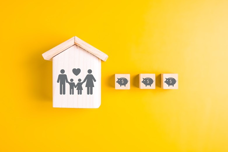 Ilustração de uma casa com uma família e vários símbolos de mealheiros para simbolizar a poupança de dinheiro.