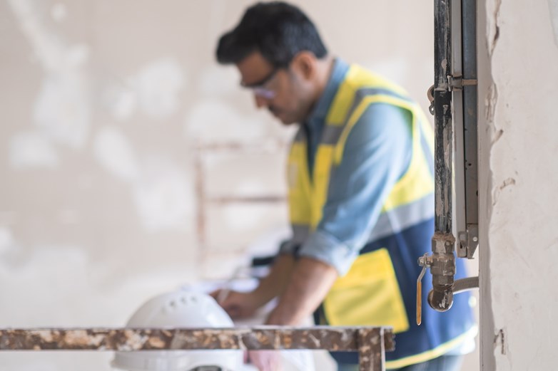 Profissional licenciado a supervisionar as obras de uma remodelação de uma casa.