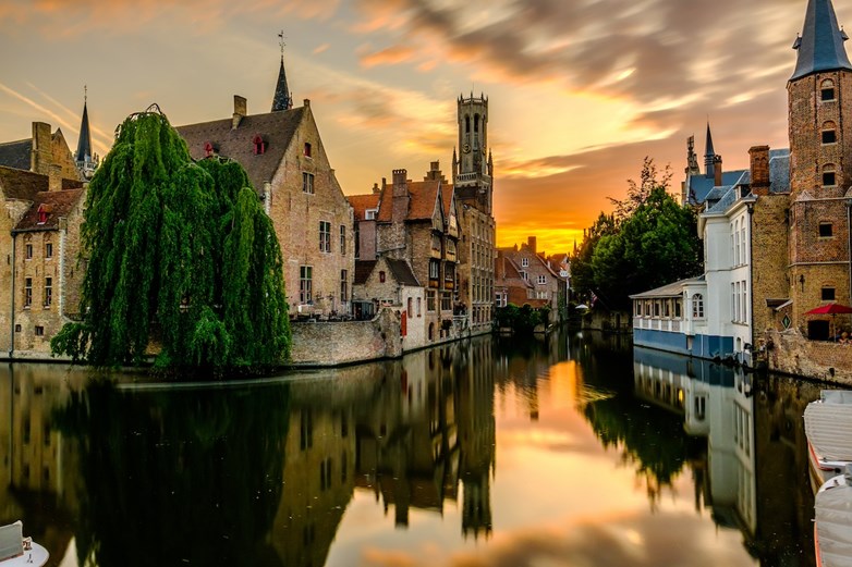 Edifícios históricos de Bruges, Bélgica, banhados pelo brilho quente do pôr do sol