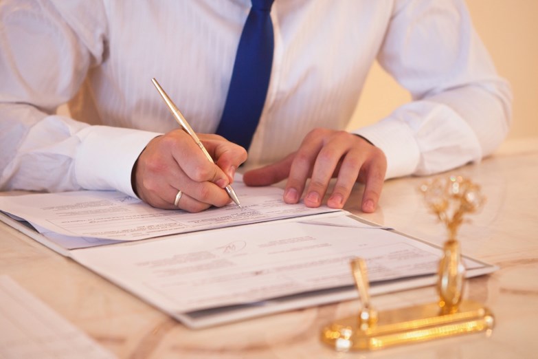 Um homem assina a documUm homem assina a documentação necessária para oficializar o seu casamento.entação necessária para oficializar o seu casamento.